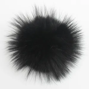 Primer plano detallado de un pompón de 15cm de piel real de mapache negro para gorros