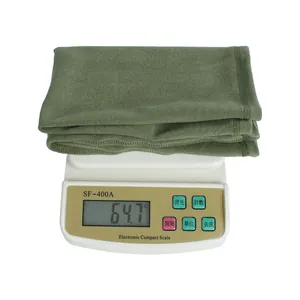 Detail van een lichtgewicht groene fleece nekwarmer van 64,7 gram op een weegschaal