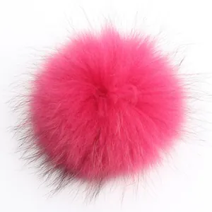Primer plano de un pompon de piel de mapache teñido fucsia de 15cm con textura suave
