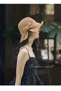 Détail de profil d'un chapeau de soleil en paille tissé main avec nœud décoratif