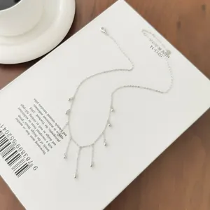 Close-up detail of a minimalist S925 sterling silver fringe necklace with dainty bead charms