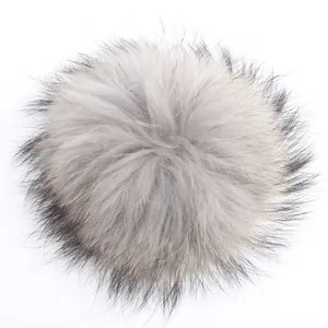 Vista detallada de un pompón de 15cm de piel real de mapache en color gris natural suave.