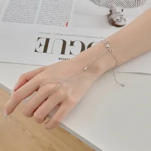 Gros plan d'un bracelet de main en argent avec breloque cœur LOVE et zircon.