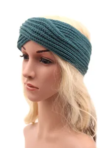 Macro detail view of a bohemian hand-knitted twisted teal yarn headband for women on a mannequin