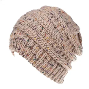 Dettaglio ravvicinato del berretto in maglia beige con trama di filato coriandoli.