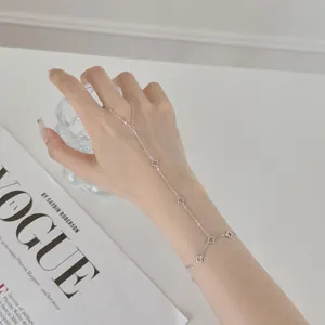 Vue détaillée de la chaîne de main trèfle en argent sterling S925 sur le poignet féminin