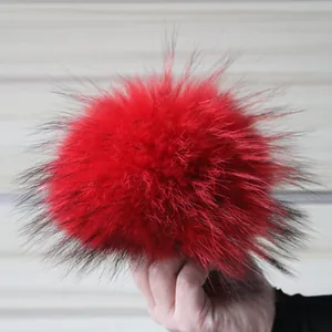 Primer plano de un pompón de piel de mapache roja de 15 cm para gorros y accesorios.