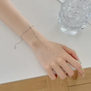 Gros plan d'un bracelet bague en argent S925 avec un design de trèfle délicat sur la main