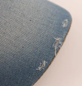 Nahaufnahme der Details des distressed Vintage blauen Denim-Baseballkappen-Gewebes