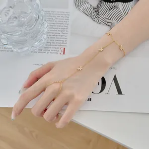 Détail d'un élégant bracelet de main doré orné de breloques papillon en zircone cubique