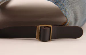 Detailaufnahme einer Vintage-Jeans-Baseballkappe mit verstellbarem Lederriemen und Metallschnalle