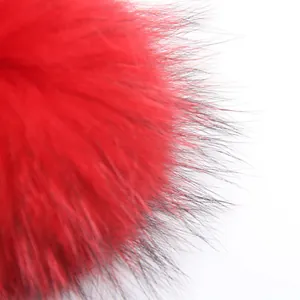 Primer plano de un pompón de piel de mapache rojo de 15cm con textura muy suave