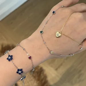 Detailed view of dainty S925 sterling silver heart and flower jewelry worn on hand