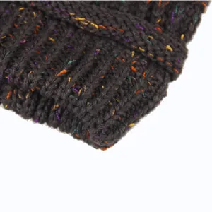 Dettaglio ravvicinato di un berretto in maglia grigio scuro con trama di filati colorati