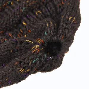 Dettaglio ravvicinato di un berretto in maglia marrone scuro con filato coriandoli