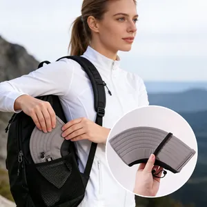Detail view of a gray foldable sun hat being stored in a black backpack pocket.