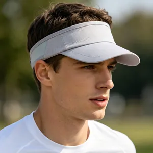 Detailed view of a breathable grey athletic sun visor hat worn by a male model outdoors