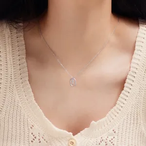Close-up of S925 sterling silver necklace with sparkling letter T pendant on neck
