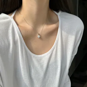 Détail rapproché d'un pendentif rond en moissanite étincelant sur collier argent S925