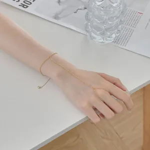 Vue macro détaillée d'un bracelet de doigt minimaliste en argent doré porté sur une main