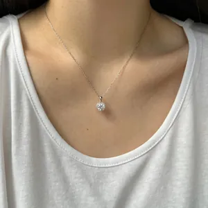 Gros plan d'un pendentif rond en moissanite sur une chaîne en argent sterling S925.