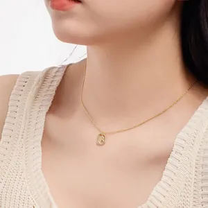Close-up of a gold-plated S925 silver necklace with a crystal initial R pendant on a model