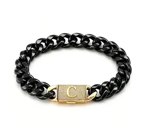 Dettaglio della chiusura con iniziale C dorata e cristalli su un bracciale nero