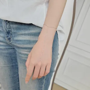 Gros plan d'un bracelet de doigt minimaliste en argent S925 porté sur la main d'un modèle
