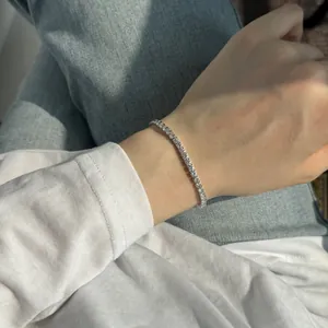 Vue détaillée d'un bracelet de tennis en moissanite étincelant en argent sterling S925 au poignet