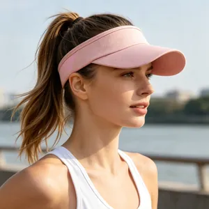 Side view profile of a young woman wearing a pink athletic sun visor hat outdoors