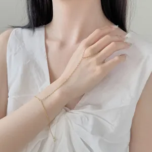 Vue détaillée d'un délicat bracelet bague en argent S925 doré sur la main d'une femme