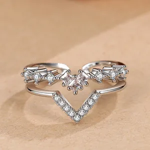 Macro view of a silver V-shaped double-layer ring featuring sparkling heart-shaped zircons