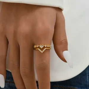 Close-up of elegant V-shaped and heart-shaped gold rings set with sparkling zircons.
