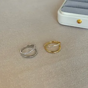 Close-up of gold and silver S925 sterling silver rings with irregular line design.