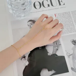 Détail de la fine chaîne de main dorée avec bague au doigt délicate