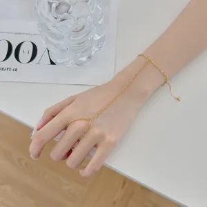 Gros plan élégant d'un délicat bracelet de main doré en forme de cœur sur une main de femme