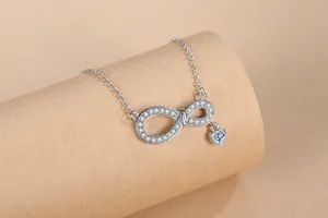 Detailed macro shot of an elegant infinity symbol necklace featuring pavé heart zircon stones