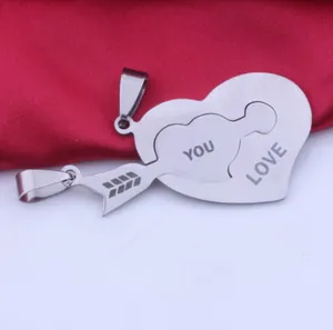 Close-up of stainless steel heart and arrow pendant set for couples with YOU LOVE engraving