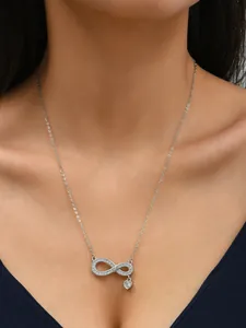 Close-up of infinity heart necklace with micro-set zircons on female model