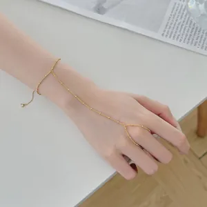 Bracelet de main minimaliste plaqué or montrant les détails de la chaîne sur la peau