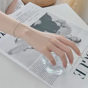 Détail d'un délicat bracelet de doigt en argent sterling S925 sur une main.