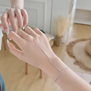 Gros plan d'une fine chaîne de main en argent S925 avec détails de perles délicates.