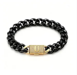 Primo piano di bracciale a catena cubana nera con chiusura a lettera 'U' dorata