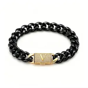 Dettaglio bracciale cubano nero in acciaio inox con chiusura dorata con lettera V tempestata