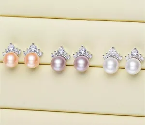 Close-up of elegant crown-shaped 8mm pearl stud earrings in three distinct colors