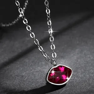 Close-up van een rode lippenketting met fonkelende kristallen details.