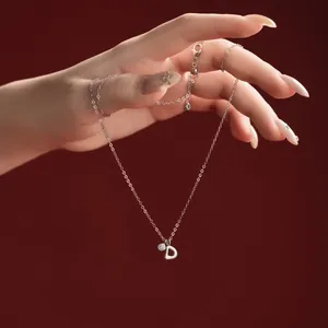 Close-up detail of a S925 sterling silver necklace with a 'D' letter pendant charm