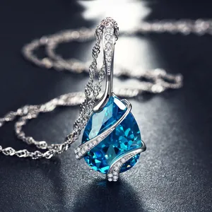 Primo piano elegante di un ciondolo in zircone blu a forma di goccia su catena argentata