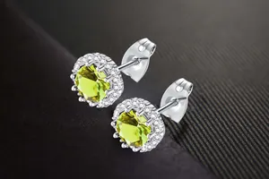 Detailed view of lime green round zircon halo stud earrings with clear accent stones.
