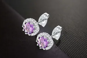 Detailed close-up of purple cubic zirconia halo stud earrings in silver-toned metal.